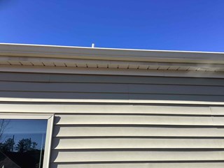 Home improvement in Durham 27703: Vinyl siding repair close-up. This image highlights the repaired siding that required professional attention.