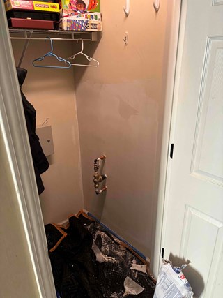 The hole in the drywall has been patched and smoothed over, with fresh paint applied to the patched area.