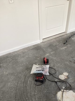 The image shows the same room after baseboard installation. White baseboards have been added along the bottom of the walls, providing a finished and polished appearance.