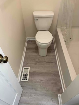 New luxury vinyl plank (LVP) flooring has been installed. The flooring now has a modern gray wood-like finish, creating a more updated and elegant look. 