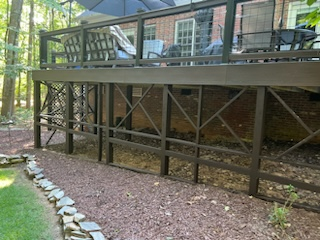 The area beneath the deck is bare, exposing the soil and cross-bracing supports and allowing wildlife to get under the deck..  
