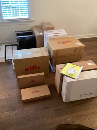 Elfa closet organization system in boxes before Ace Handyman Services assembled them. 
