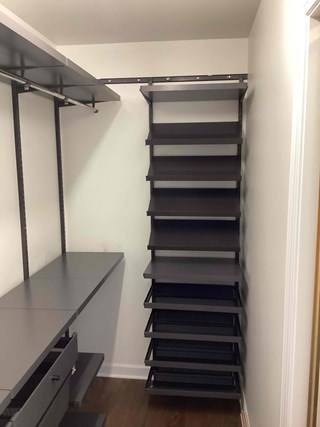 A fully assembled custom Elfa closet organization system installed in a small closet. 
