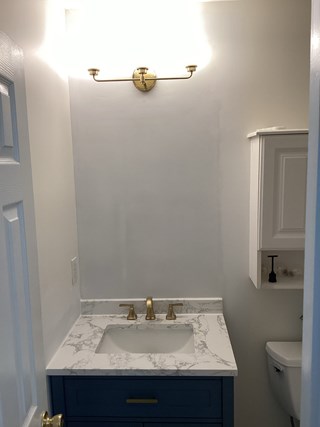 The bathroom with the vanity now fully installed and the wall behind it freshly painted.