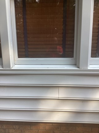 Window frame with the rot repaired. The damaged wood has been replaced, and the frame is now in good condition with no visible deterioration. The new wood is painted white and matches the surrounding frame.