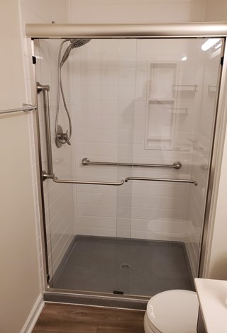 Ace Handyman Services remodeled bathroom including a new Onyx Collection base, surround, and sliding glass door and Shaw floors