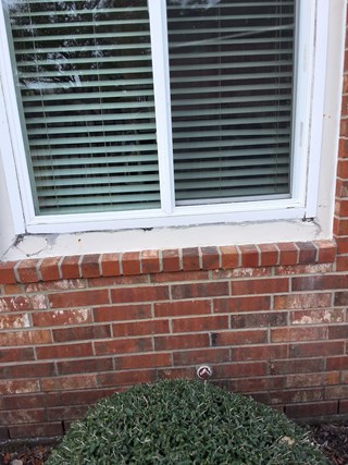 Damaged window trim and sill with cracks and worn caulking in Pearland