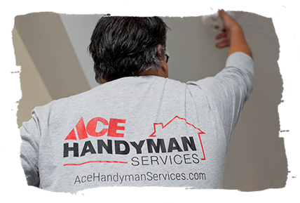 An Ace Handyman Craftsman pictured from behind reaching up to a smoke alarm on the ceiling, the back of his shirt says “Ace Handyman Services, AceHandymanServices.com.” An Ace Handyman Craftsman pictured from behind reaching up to a smoke alarm on the ceiling, the back of his shirt says “Ace Handyman Services, AceHandymanServices.com.”