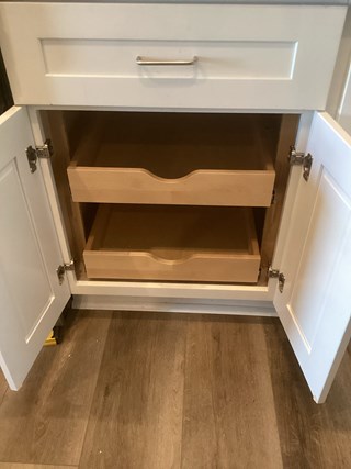 Handyman from Ace Handyman Services installing cabinet pullout drawers in a kitchen in Tri-Cities, WA, as part of home modifications for a client aging in place, enhancing accessibility and ease of use.