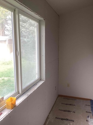 Handyman from Ace Handyman Services fixing a large drywall hole in a West Richland, WA, home.