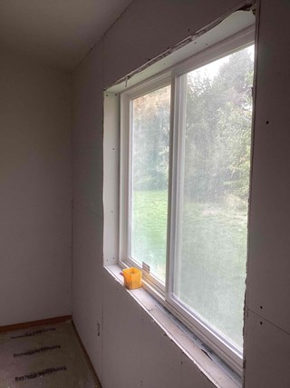 Handyman from Ace Handyman Services fixing a large drywall hole in a West Richland, WA, home.