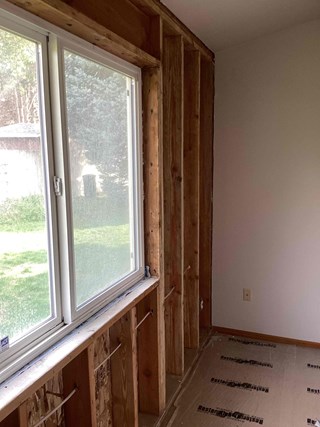 Close-up of fiberglass insulation being installed in a wall cavity in Richland, WA, by experienced handymen from Ace Handyman Services.