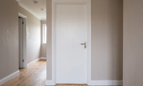 Newly installed white interior door closed in its frame with even reveal gaps and clean painted trim