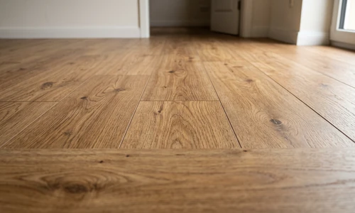 Finished laminate floor with all seams fully closed, sunlight raking across the smooth gap-free surface