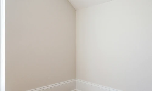 Smooth repainted interior drywall corner with a crisp straight corner line and even matte finish