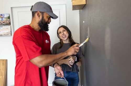 https://acehandyman-dss.ingeniuxondemand.com/Images/Offices/Arkansas/NW Arkansas/Blogs/image1 (1).jpg Woman approving paint color painter applies to wall in home