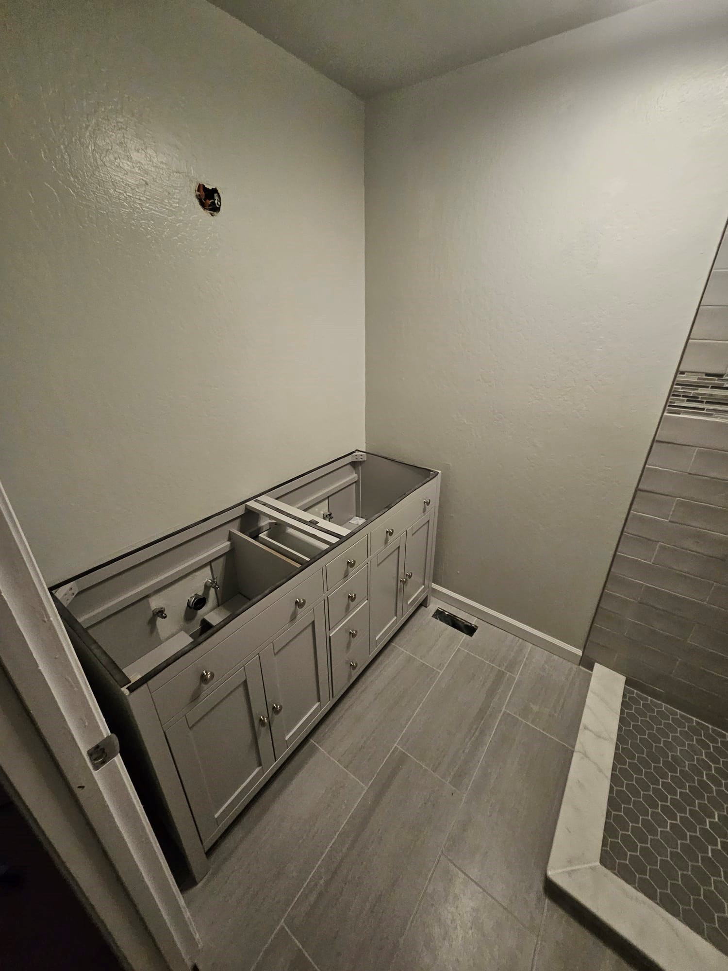 Bathroom renovation with a new cabinet and tiled floor.