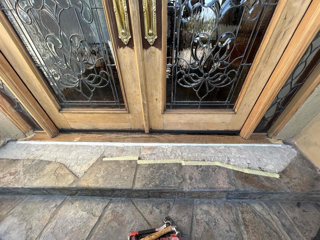 Double entry doors with a worn threshold at the stone step in Newport Beach