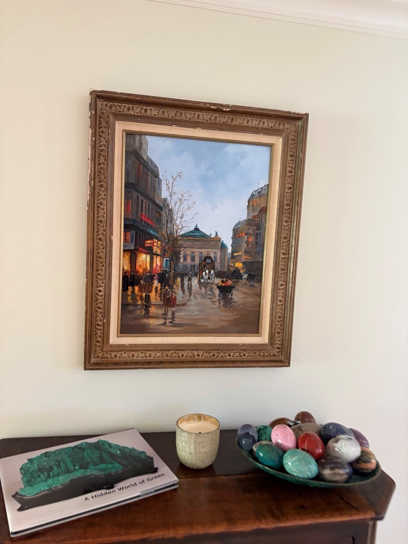 Framed oil painting hung on the wall above a wood console table in a Newport Beach home
