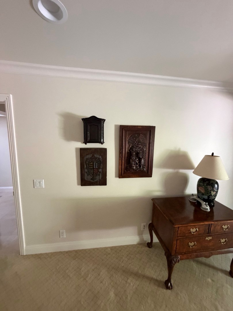 Group of small framed pictures hung on a wall beside a lamp, Newport Beach home