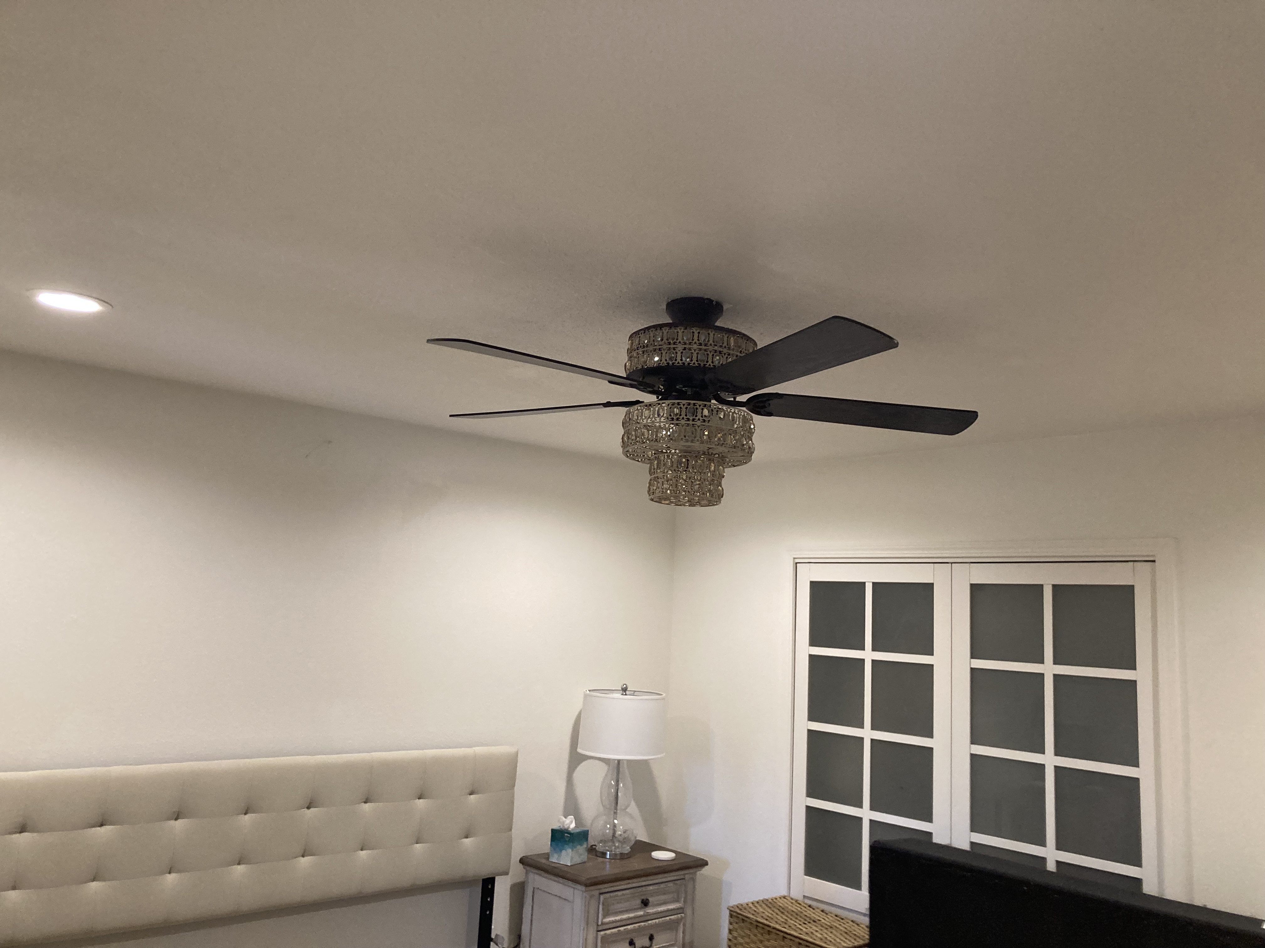 Ceiling fan with lights installed in a bedroom.