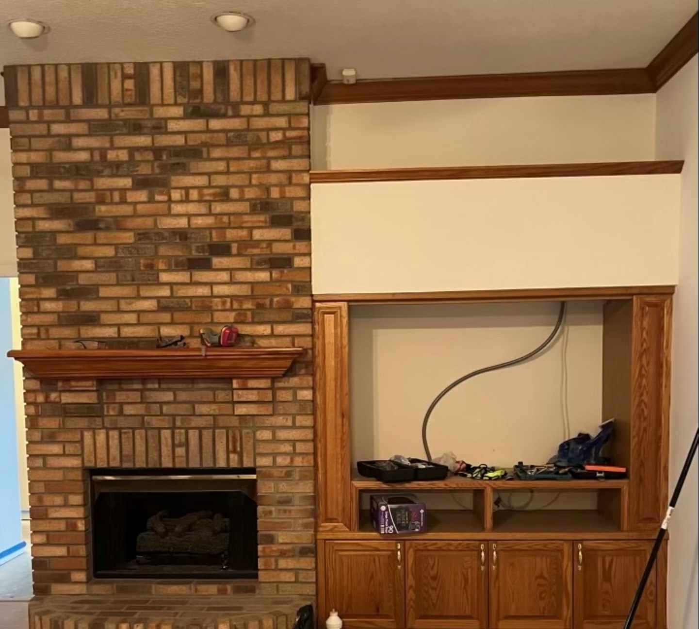Brick fireplace and wooden cabinet under renovation.