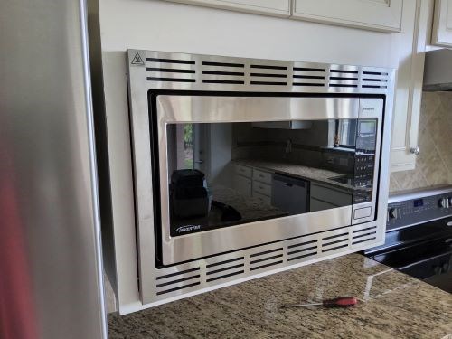 Installed microwave above granite countertop in kitchen.