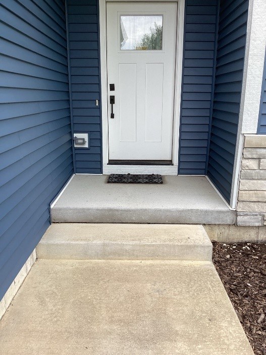 Front entrance with white metal railings before