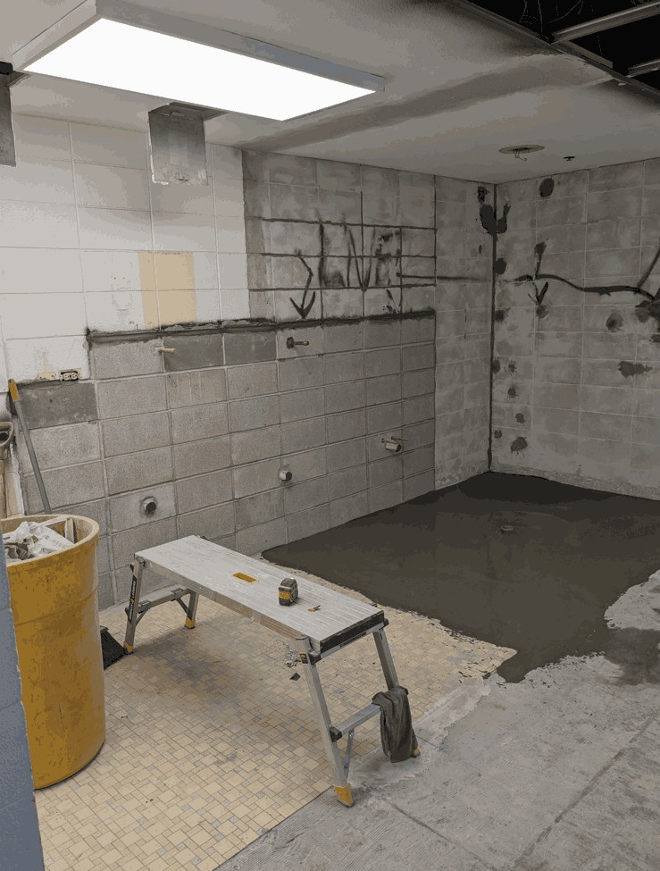 Renovation in progress; tools and wet floor visible.