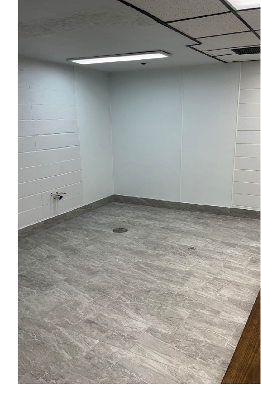 Empty room with new gray tile flooring and white walls.