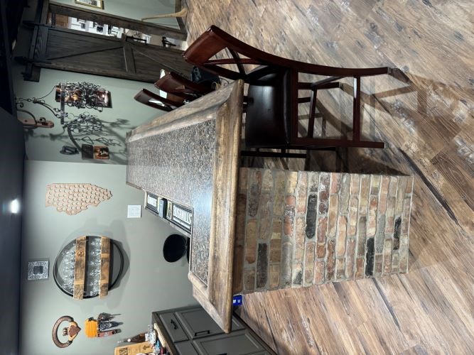 Rustic bar with brick base and wooden counter in a cozy room.