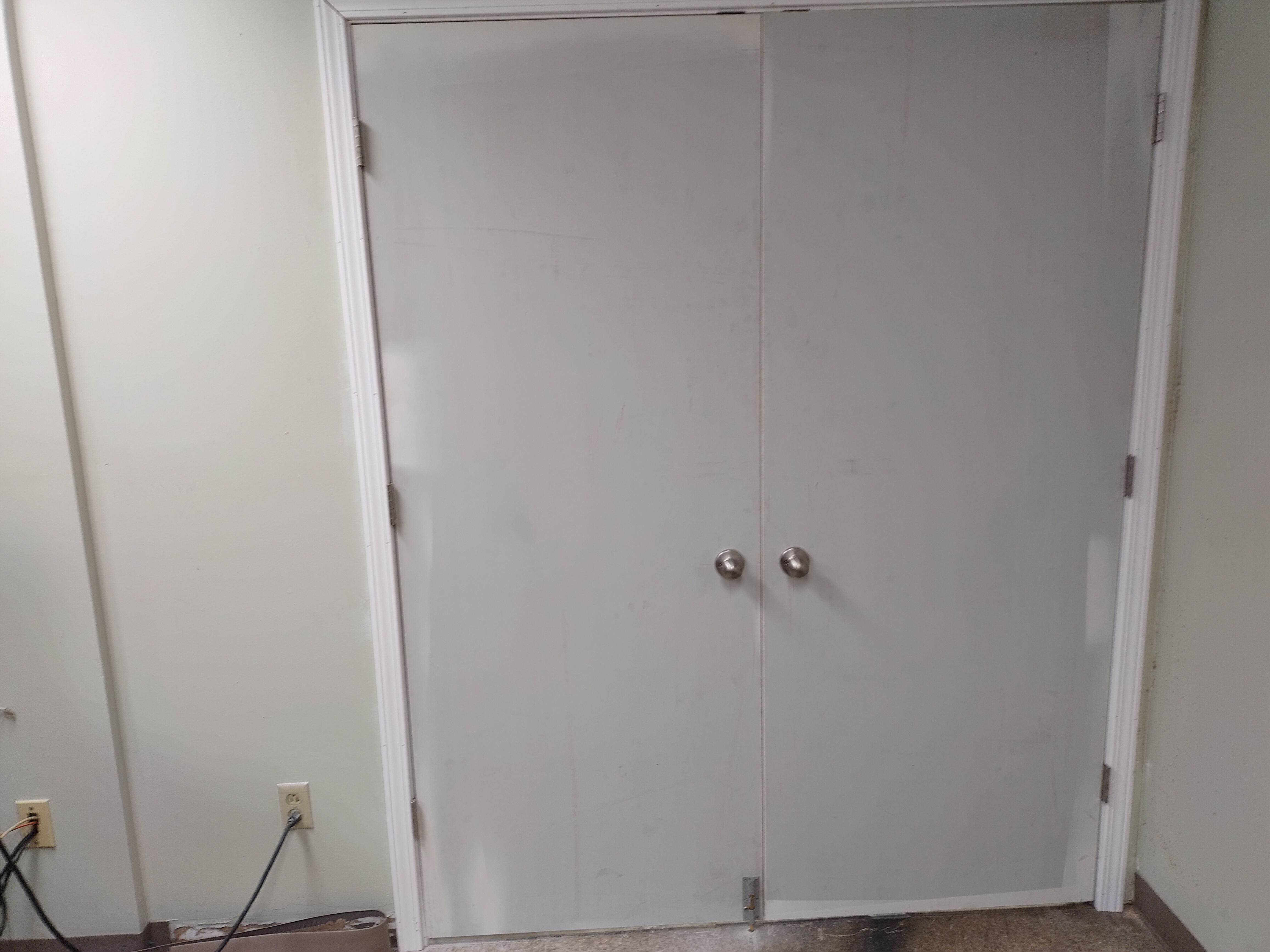 Closed double doors with white trim and metal knobs.