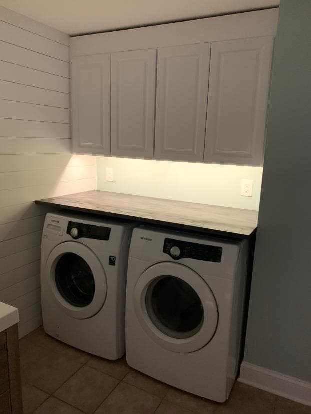 Laundry area with cabinets and new countertop above appliances.