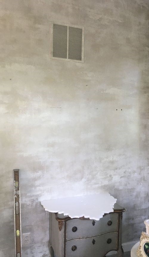 Empty textured wall with small chest and level tool.
