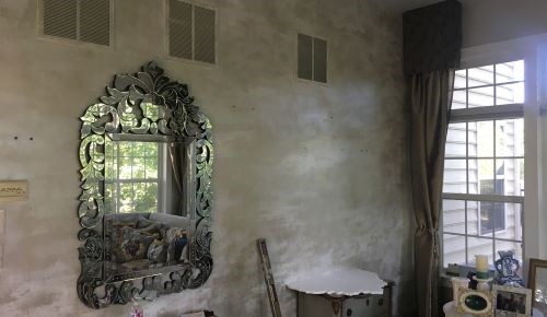 Room with ornamental mirror and covered window after project.