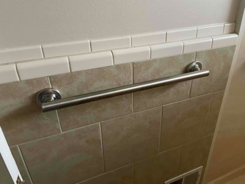Installed grab bar on tiled bathroom wall.