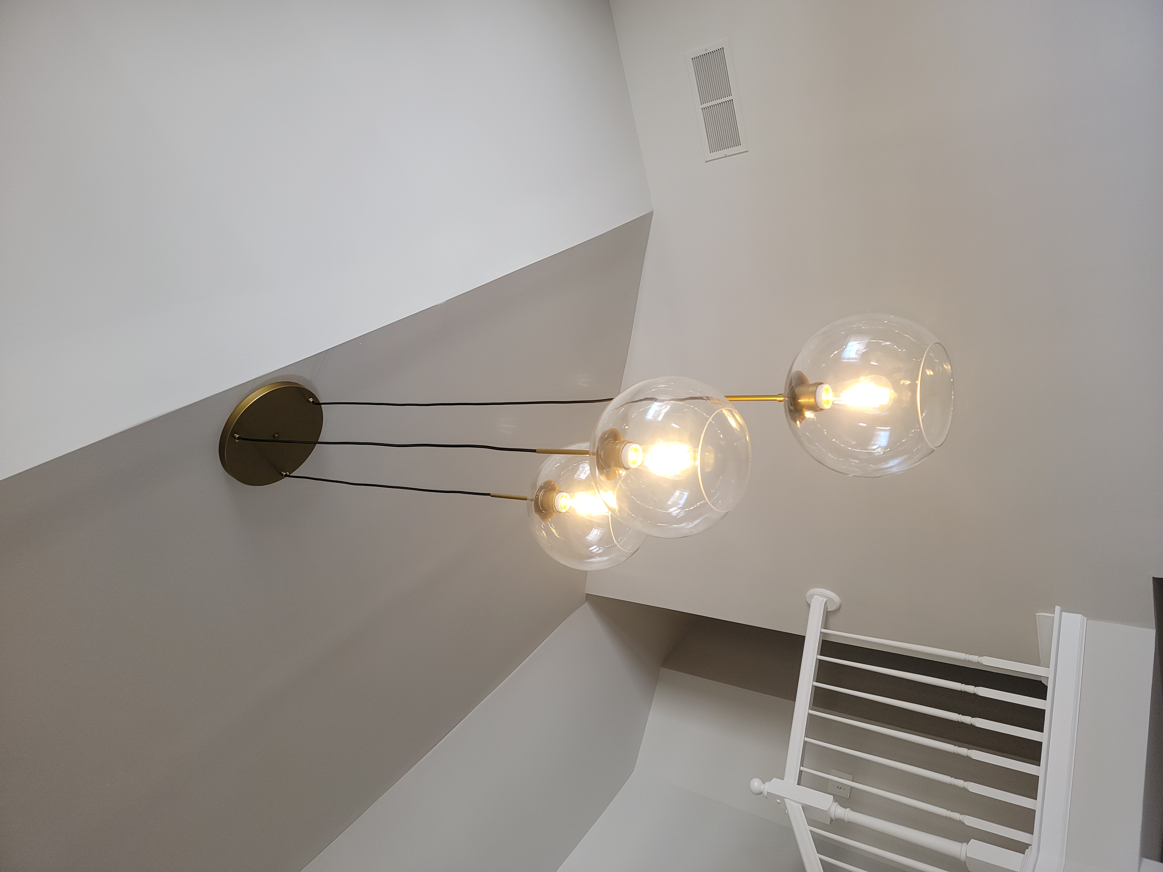 Modern pendant lights installed in a high ceiling space.