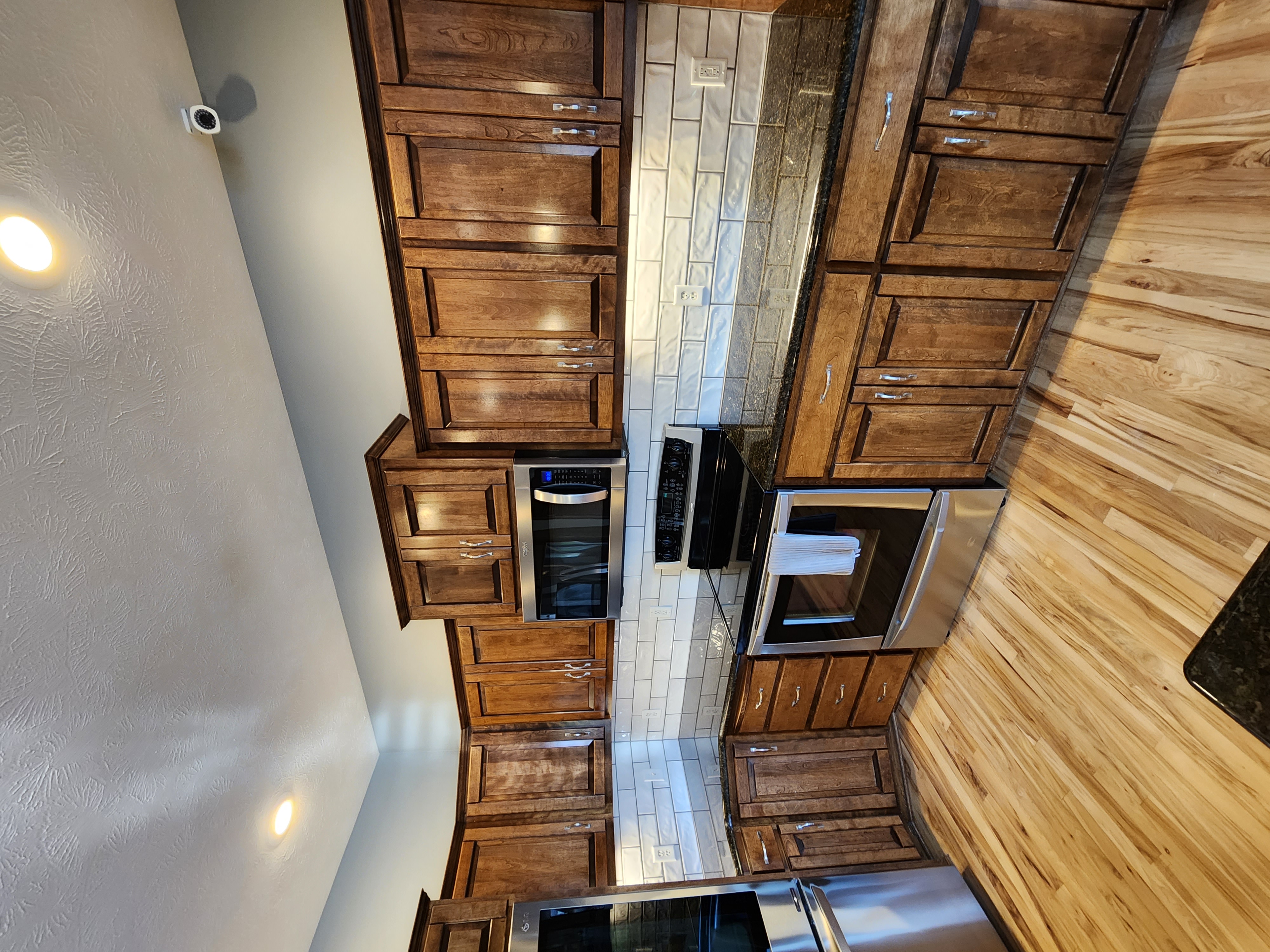 Renovated kitchen with wooden cabinets and hardwood floors