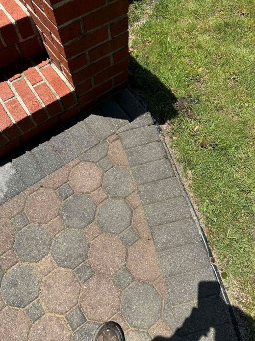 Brick steps with hexagonal pavers next to grassy lawn.
