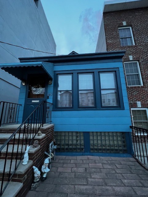 Blue house exterior with porch steps and railings.
