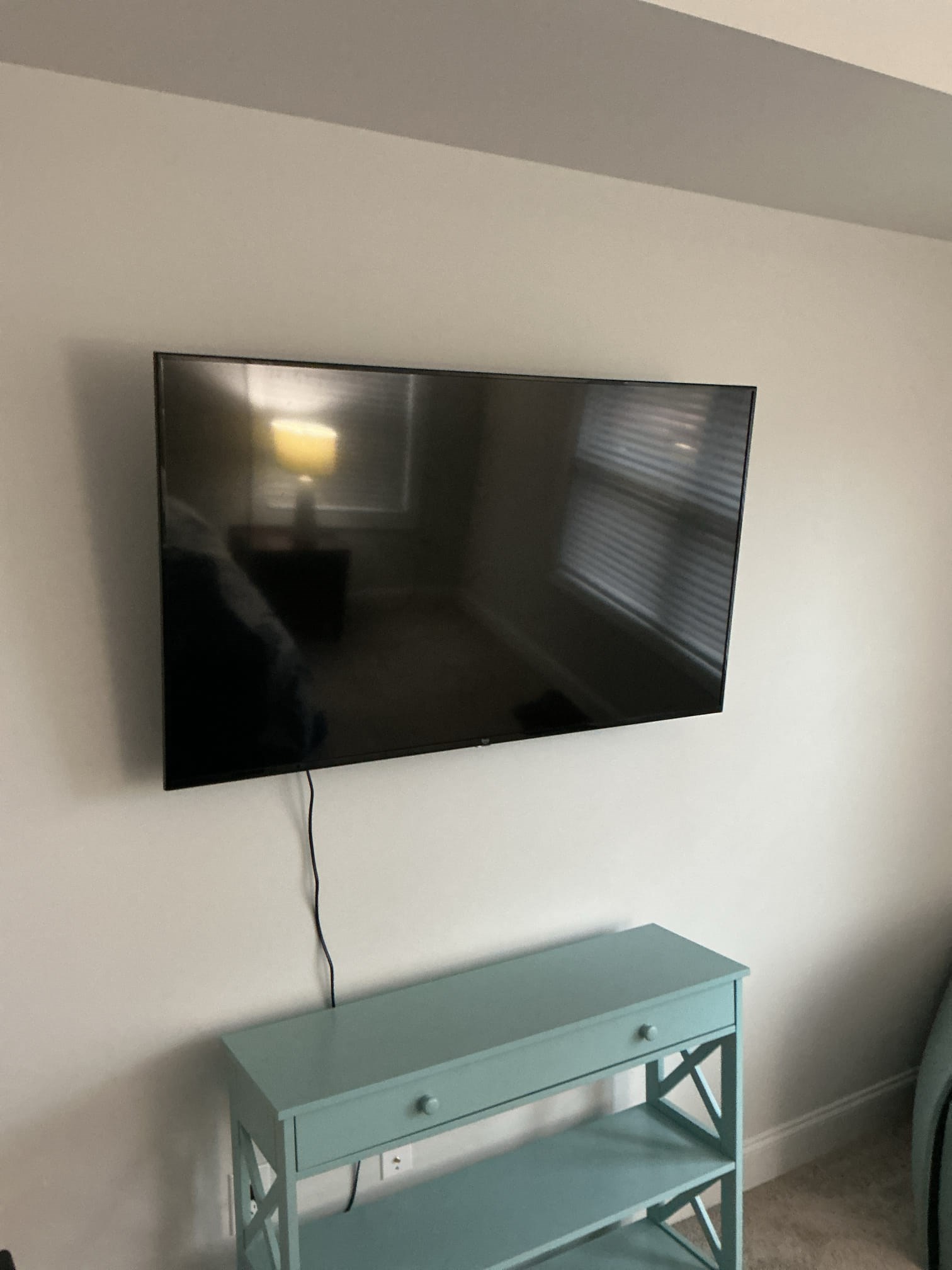Wall-mounted flat screen with component console below. A clean, practical setup.