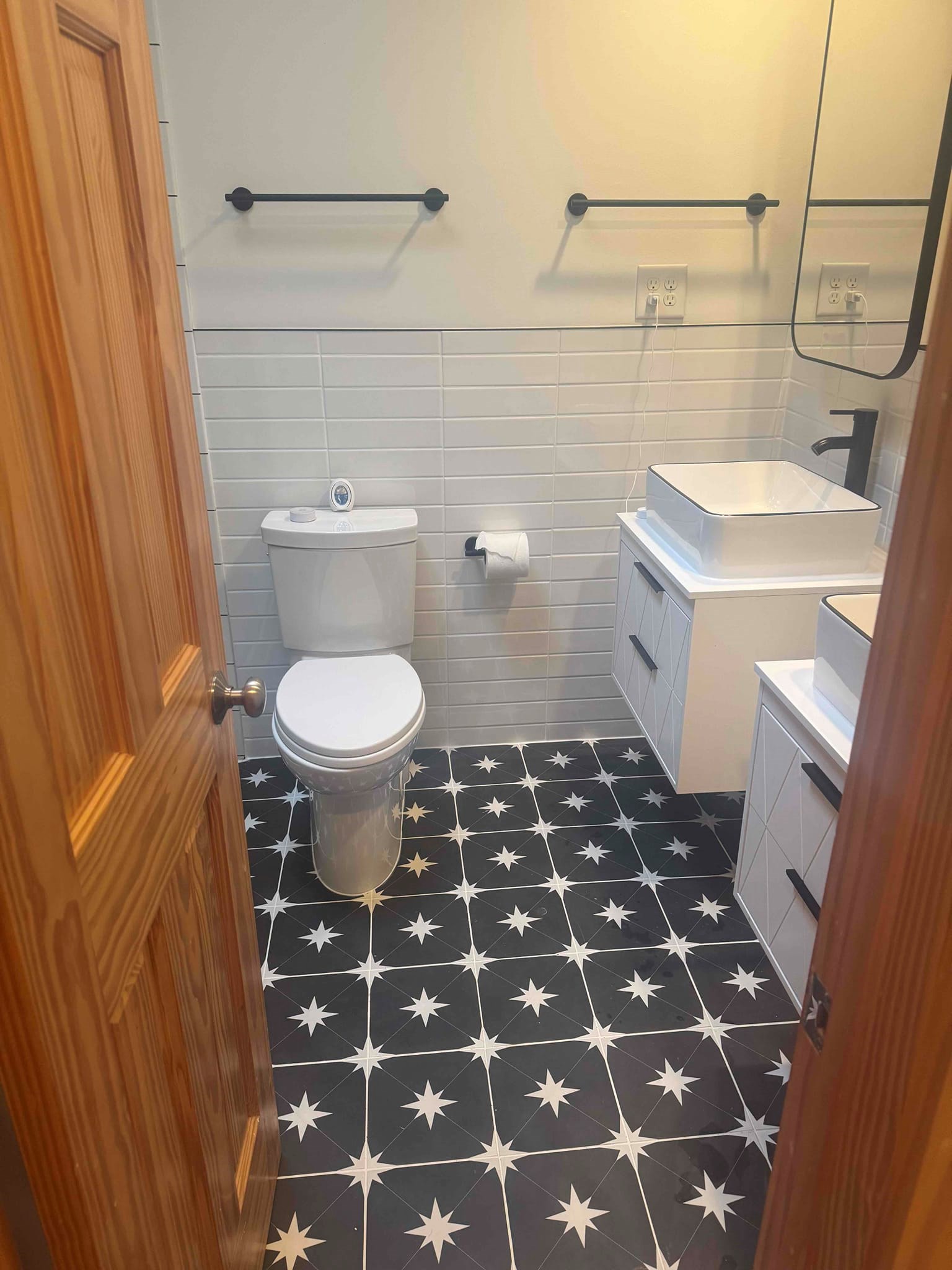 Full bathroom remodel completed in Durham NC star-pattern floor tile and floating vanities by Ace Handyman Services Durham Chapel Hill