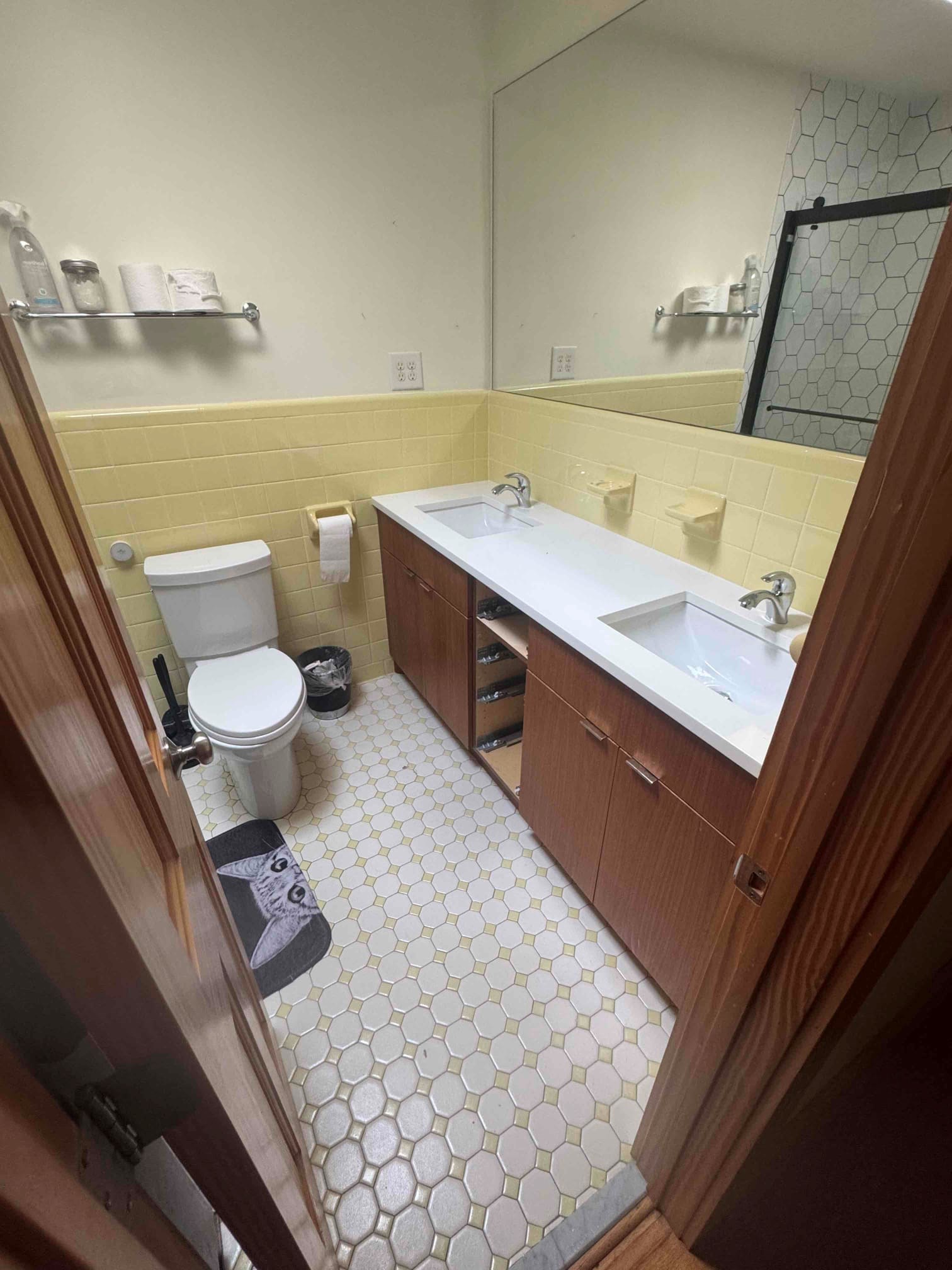 Bathroom remodel completed in Durham NC — dual vessel sinks, black accent wall, and star-pattern tile by Ace Handyman Services