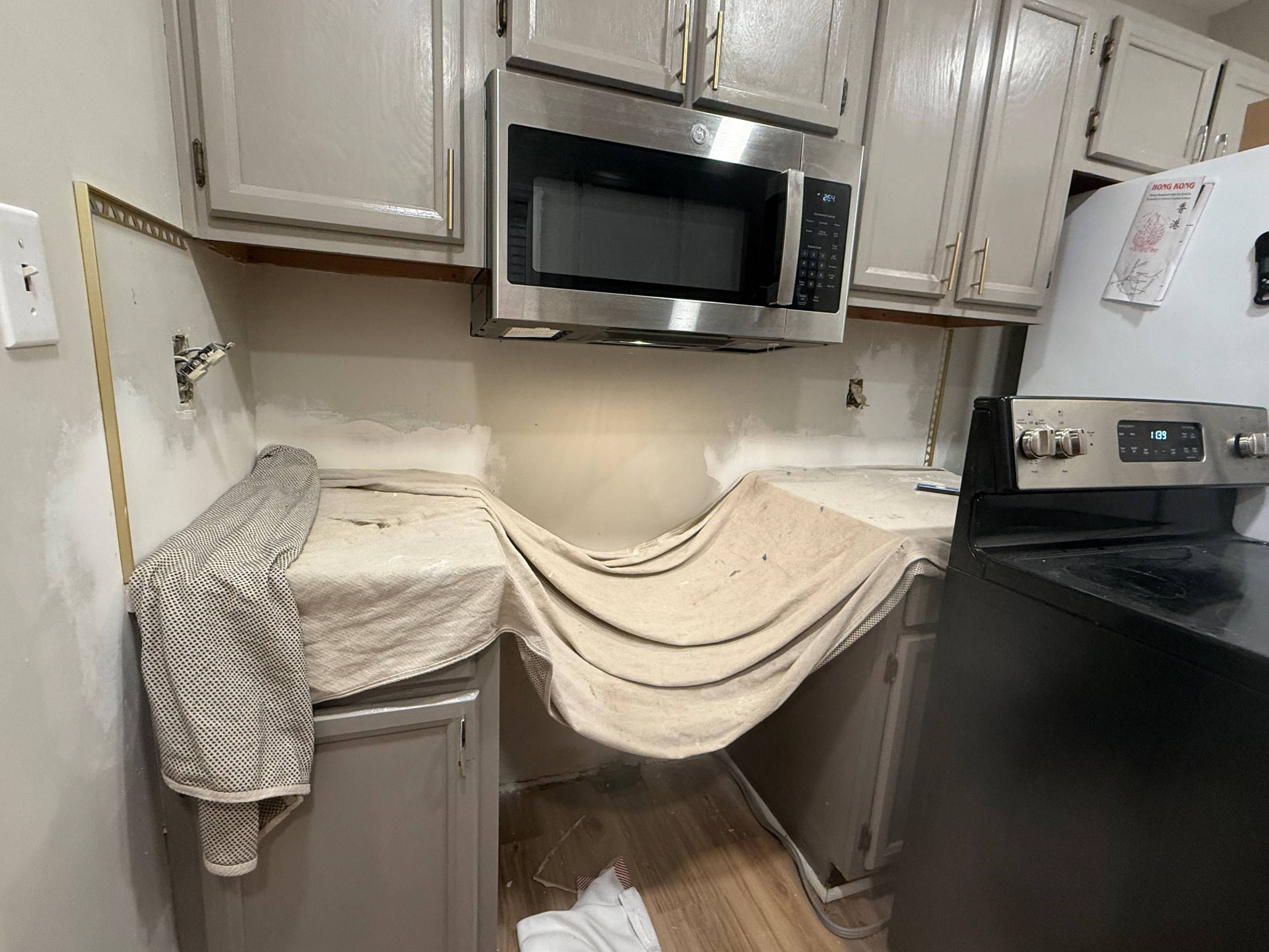 https://acehandyman-dss.ingeniuxondemand.com/Images/Offices/North Carolina/Durham Chapel Hill/38911515-ace-handyman-services-durham-27707-kitchen-backsplash-prep-drywall-before.jpg Covered kitchen cabinets during a backsplash and butcher block installation in Durham NC