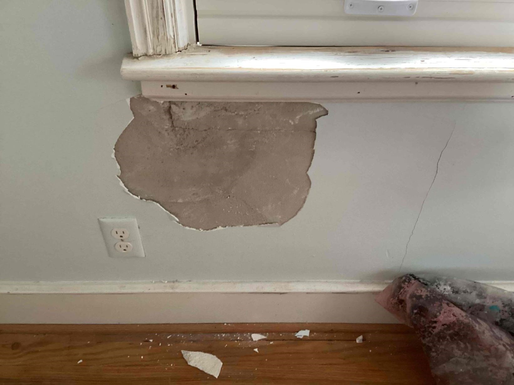 Exposed plaster wall damage below a window in an older Chapel Hill, NC home before repair by Ace Handyman Services