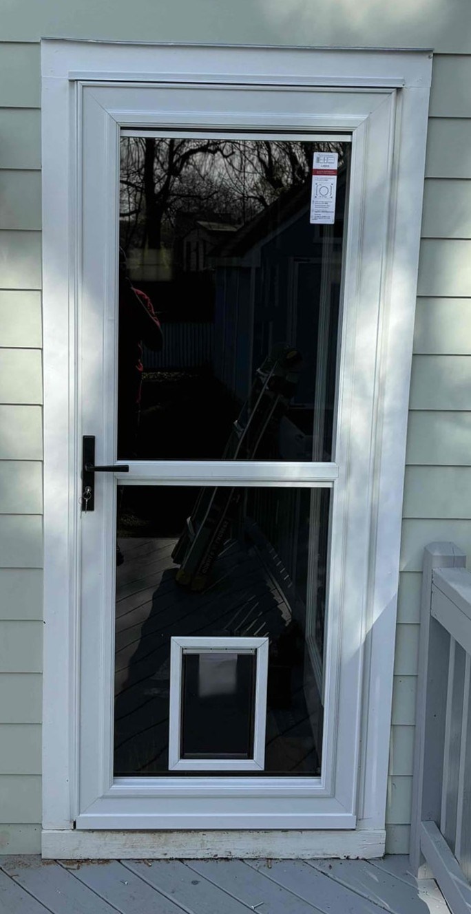 https://acehandyman-dss.ingeniuxondemand.com/Images/Offices/North Carolina/Greater Triangle/Photos/17183011-ace-handyman-services-greater-triangle-raleigh-nc-27601-storm-door-pet-door-installation.jpg White full-view storm door with built-in pet door installed at a downtown Raleigh, NC home by Ace Handyman Services