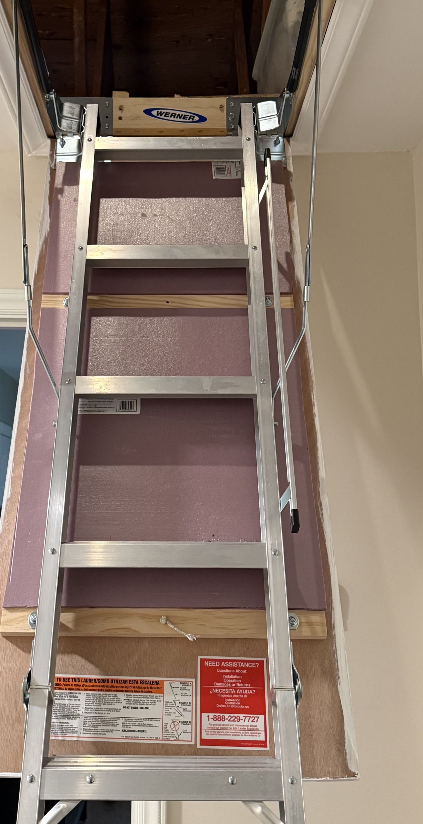 Pull-down attic ladder with a rigid foam insulation panel fastened to the hatch door, installed in a Raleigh 27608 hallway