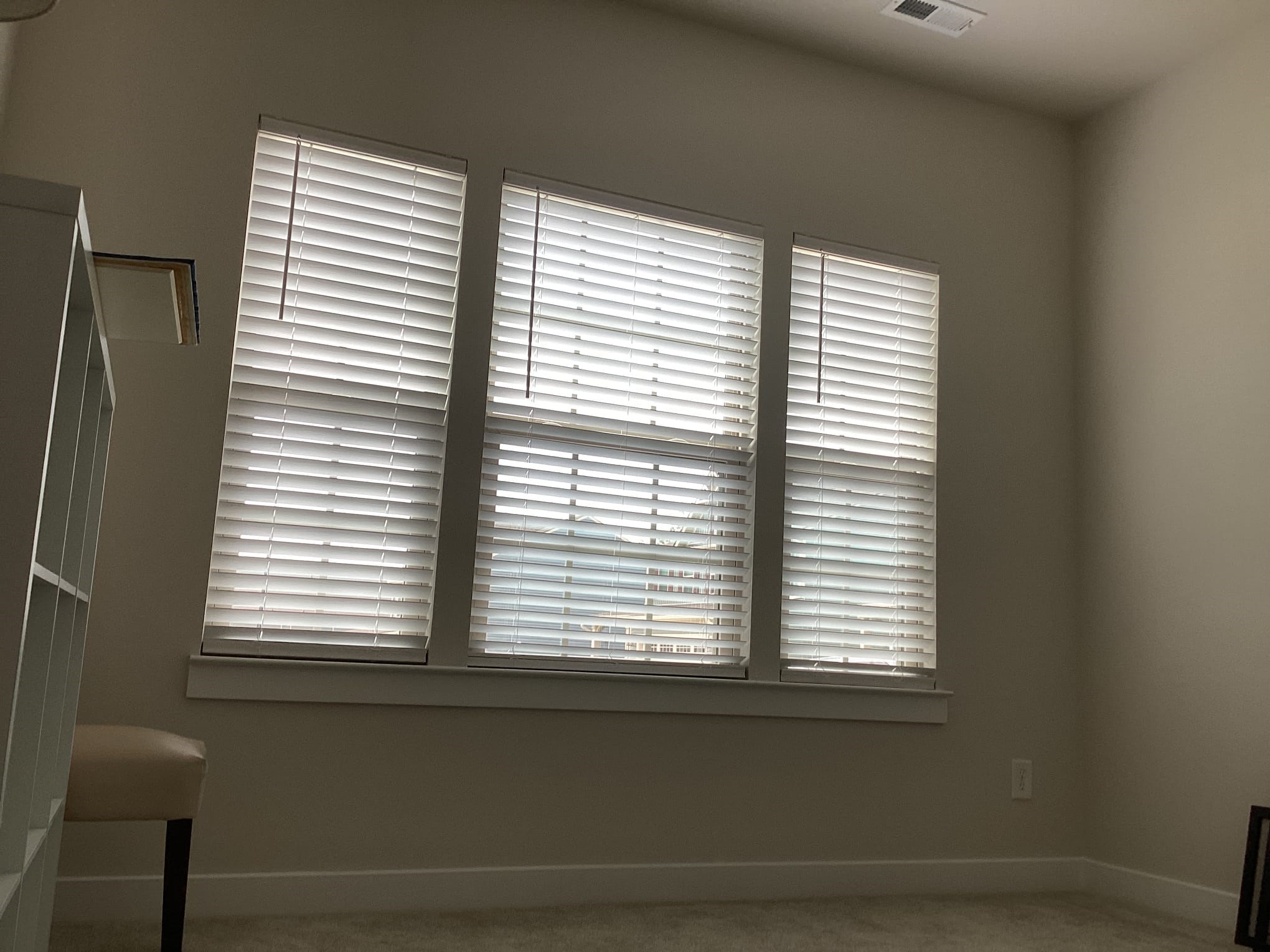 Room with closed blinds, open ceiling panel, and light walls.
