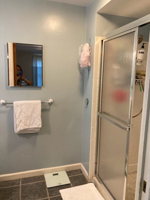 Bathroom with mirror, towel, and a glass shower door.