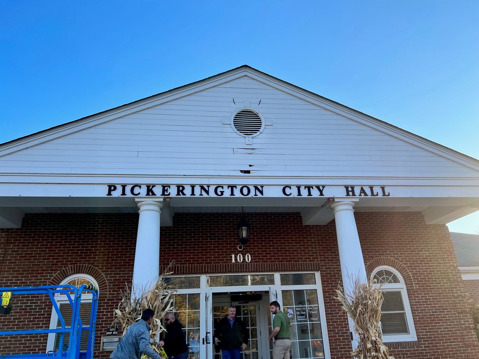 Pickerington City Hall entrance with people arranging decorations.